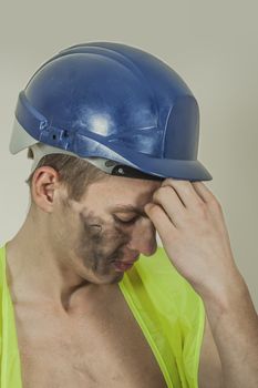 Closeup of a stressed collar worker with a headache.