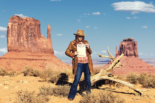 cowgirl holding wanted paper at Monument Valley