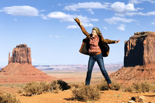 happy cowgirl jumping at Monument Valley, Utah, USA