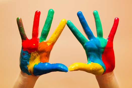 Painted hands, colorful fun. Creative, funny and artistic means happy! Orange background wall