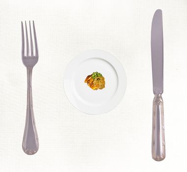 Diet concept: Stop Eating! Big fork and knife and small portion of the meal