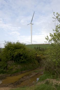 wet mucky dirt road to a windmill on lush irish countryside landscape in glenough county tipperary ireland