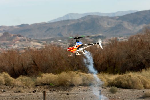 RC helicopter in flight in front of mountains