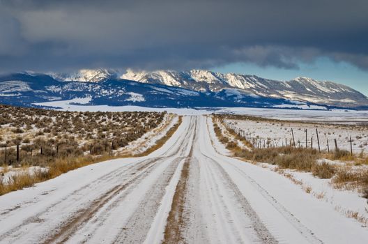 Rural road, the Bridger Mountains and low clouds in winter, Gallatin County, Montana, USA