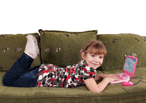 little girl lying on bed with laptop