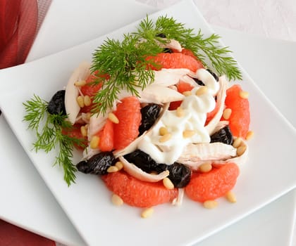 Salad of grapefruit and prunes with chicken, covered with pine nut yogurt