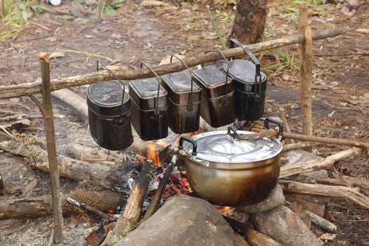 cooker food in pot on fire at camping place