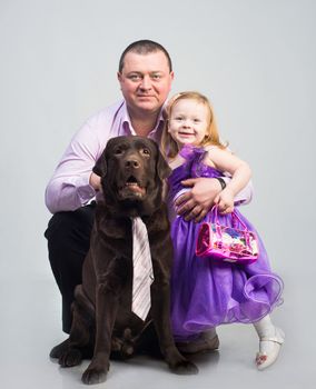 Father and daughter with black dog in studio