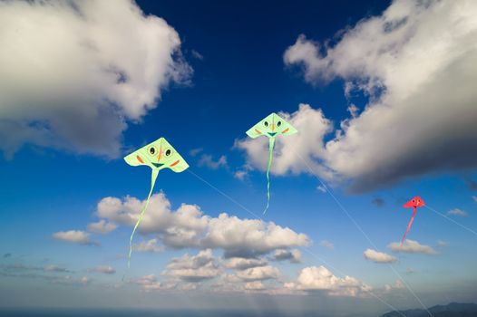 Flying colourful kites in blue sky
