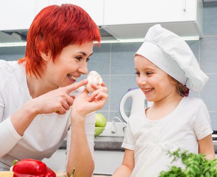 Mother and daughter in the kitchen with mushrooms