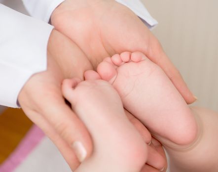 doctors's hands massaging little baby's foot