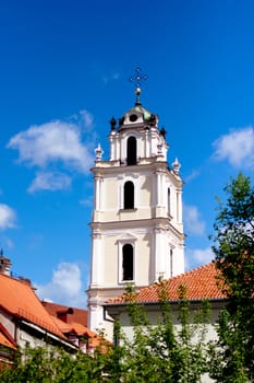 A pink belltawer and blue sky in Vilnius
