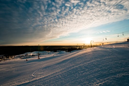 Ski resort at sunrise with few tracks and trails