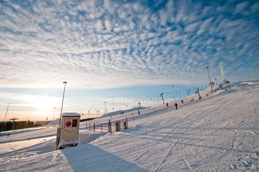 Ski slope at sunrise with few tracks and trails