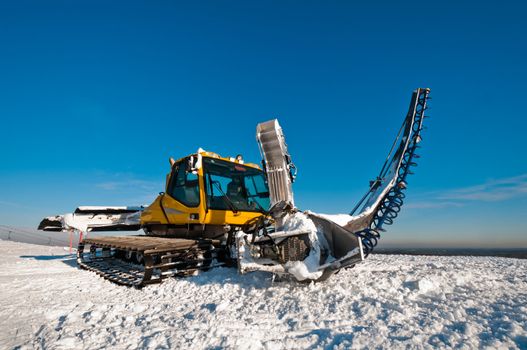 Snowcat for making half pipes, standing on top of the mountain
