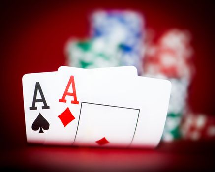 Stack of chips and two aces on a poker table