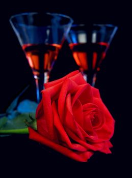 Gentle red rose and liquor in a glasses on a black background