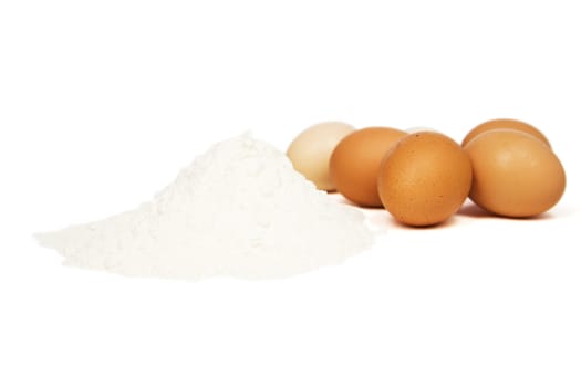 Flour and eggs for the dough on a white background