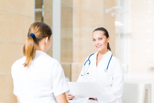 two doctors talking in the lobby of the hospital, sitting on the couch