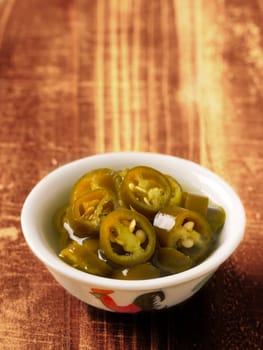 close up of a bowl of asian pickled green chilies
