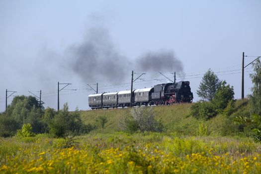 Old retro steam train passing through polish countryside
