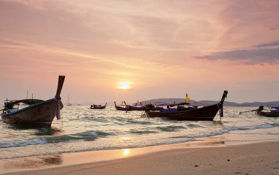 Longtail boats against a sunset. Ao-Nang, Thailand.