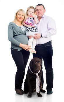 Family with black retriver in studio on a white