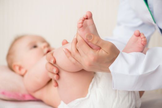 Doctor massaging little baby girl