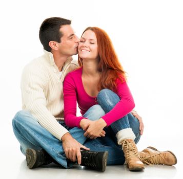 Young happy couple kissing on white background
