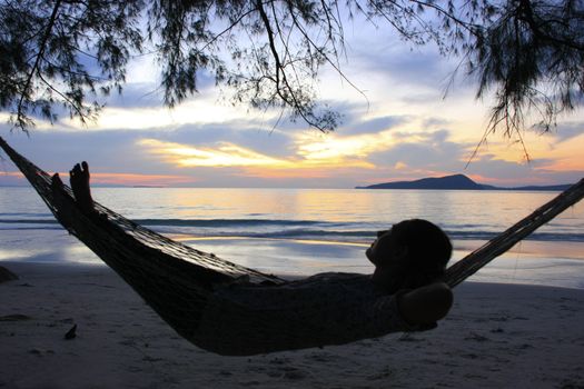 Young woman enjoying sunrise at Koh Rong island, Cambodia, Southeast Asia