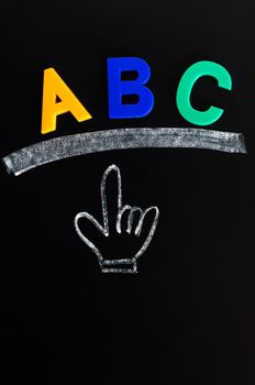 Dash and hand cursor drawn in chalk on a blackboard with ABC