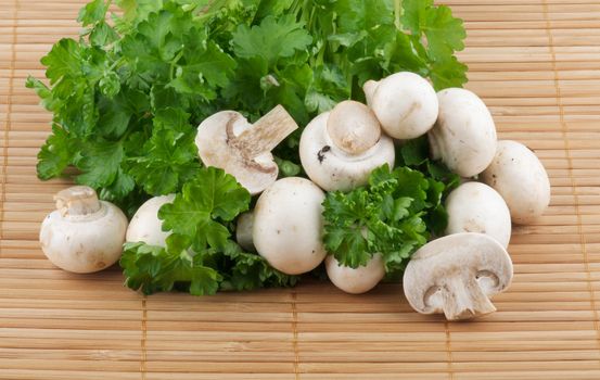 White Champignon Mushroom with parsley on wooden background