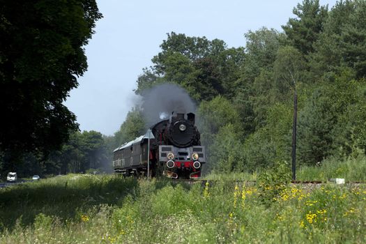 Old retro steam train passing through polish countryside
