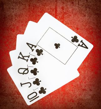 Royal flash of clubs on grunge poker table