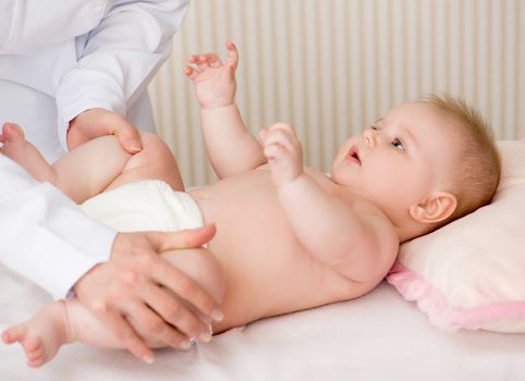 Doctor massaging little baby's legs