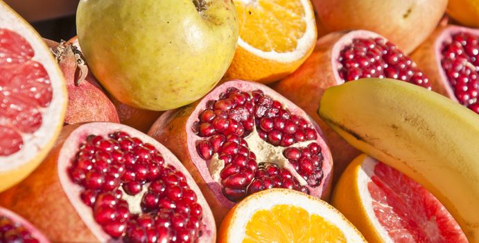 Detail of an open pomegranate with whole ones in the background