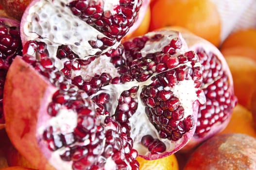 Detail of an open pomegranate with whole ones in the background