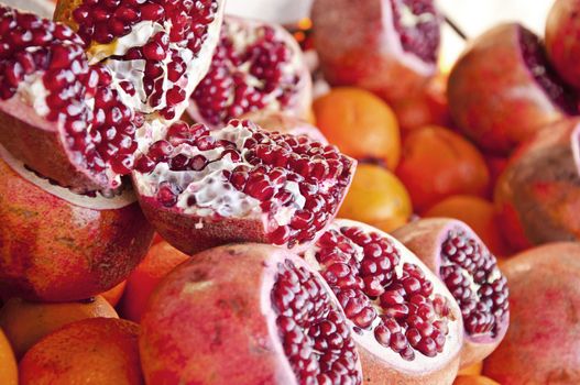 Detail of an open pomegranate with whole ones in the background