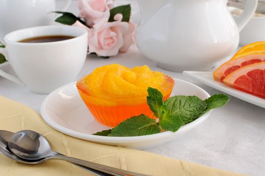 Dessert of orange jelly with fresh orange slices with a cup of coffee