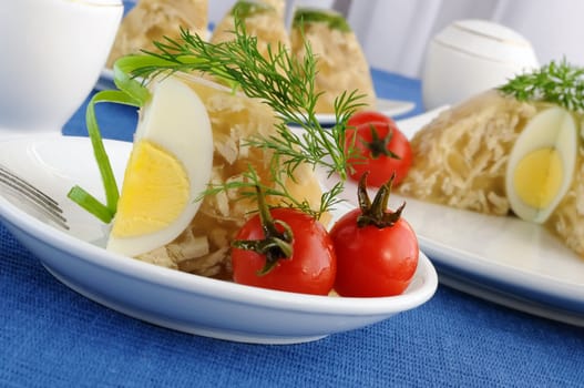 A piece of jellied chicken with egg and pickled cherry