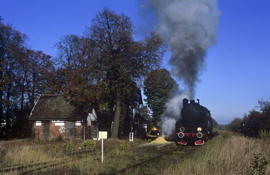 Old retro steam train stopped at the small station
