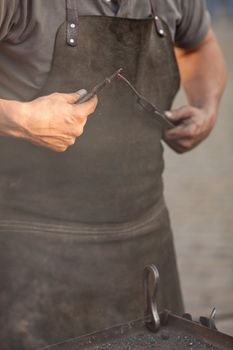 embers, fire, smoke, tools and the hands of a blacksmith