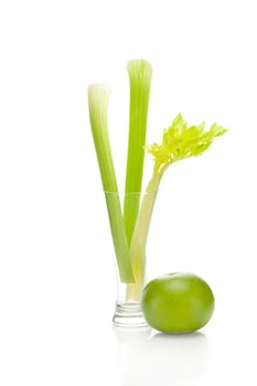 celery in a tall glass and green grapefruit isolated on white