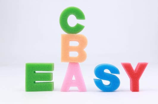 Easy word spelled out with concept of "easy as ABC" on white background.