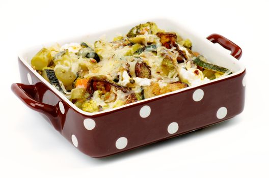Brown Polka Dot Casserole Dish with Vegetables, Broccoli, Zucchini, Cream Cheese and Spices isolated on white background