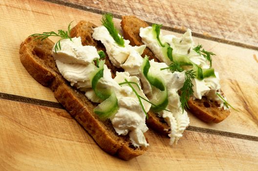 Cream Cheese Sandwiches with Chives, Cucumber, Dill and Whole Wheat Bread closeup on Wooden background