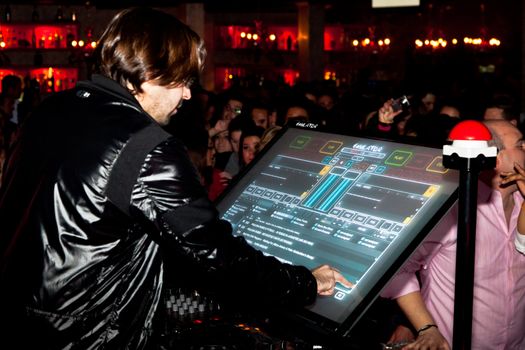 CHICLANA, SPAIN - JAN 27: DJ Alvaro Reina next to the mixer to begin the party of the hot mix energy danceflor of the Los 40 Principales  on Jan 27, 2012 in Chiclana, Spain