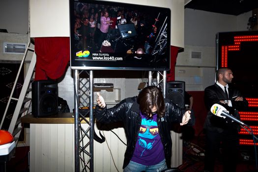 CHICLANA, SPAIN - JAN 27: DJ Alvaro Reina next to the mixer to begin the party of the hot mix energy danceflor of the Los 40 Principales  on Jan 27, 2012 in Chiclana, Spain