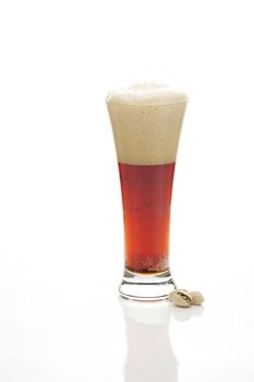 dark  beer with the foam in a tall glass and pistachios isolated on white