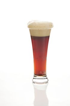 dark beer with the foam in a tall glass isolated on white